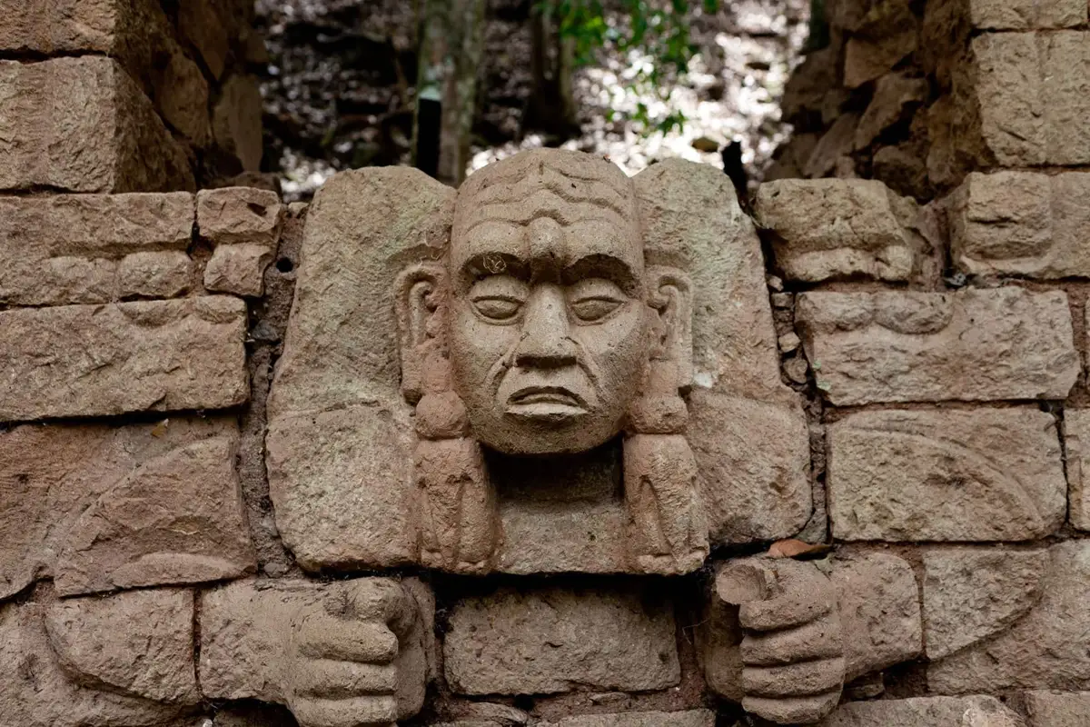 Carved stone face in a Copán temple wall seen on San Pedro Sula Mayan ruins tours