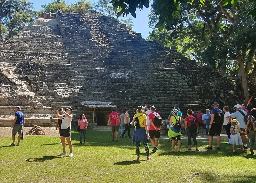 Visitors at the foot of a stepped temple on San Pedro Sula Mayan ruins tours to Copán